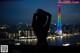 A woman standing in front of a city skyline at night.