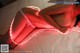 A woman laying on a bed with a red light on her back.