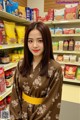 A woman standing in front of a shelf of food.