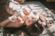 A woman laying on a rug with flowers in her hair.