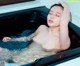 A naked woman is sitting in a bathtub with water.